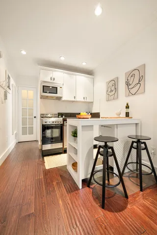 a view of a room with wooden floor and a bathroom