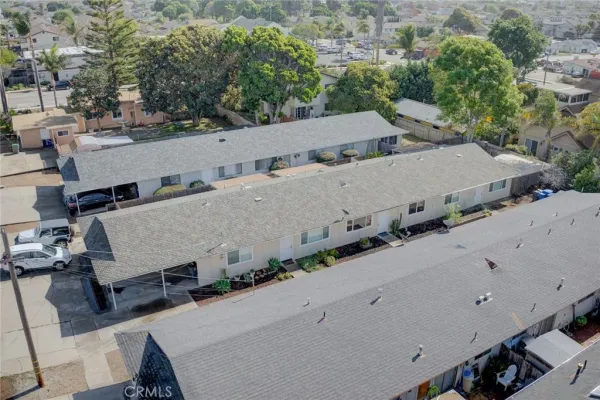 an aerial view of a house with a yard and mountain view in back