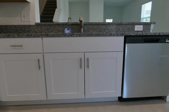 a kitchen with granite countertop cabinets and white appliances