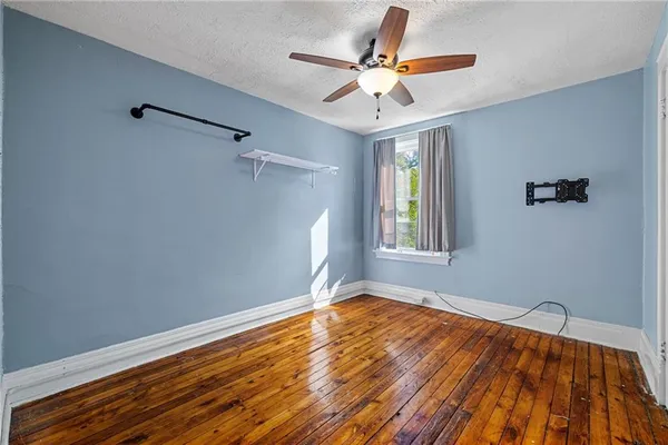 a view of a livingroom with wooden floor and a ceiling fan