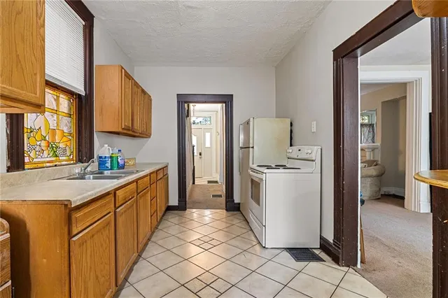 a kitchen with a sink stove and a refrigerator