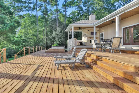 a view of a patio with table and chairs wooden floor and fence