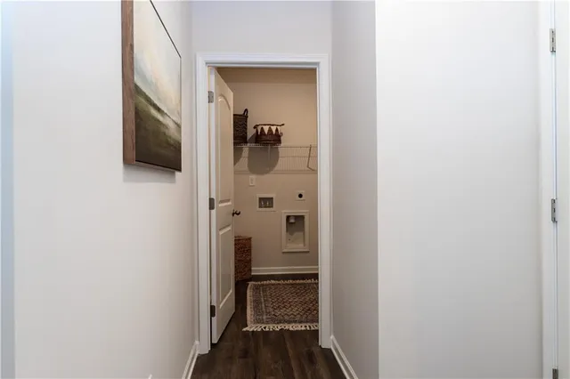 a view of a hallway with wooden floor and closet