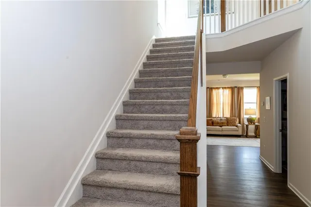 a view of staircase with lots of frames on wall and a window