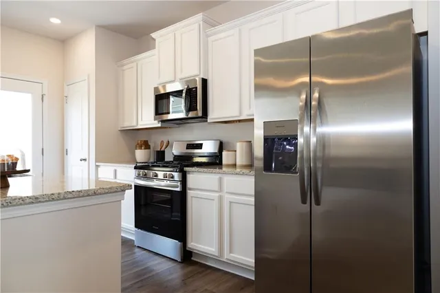 a kitchen with stainless steel appliances cabinets a microwave and a refrigerator