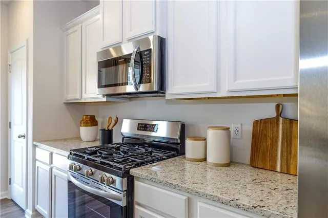 a kitchen with granite countertop cabinets and steel stainless steel appliances