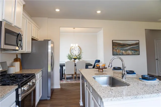 a kitchen with stainless steel appliances granite countertop a sink stove and refrigerator