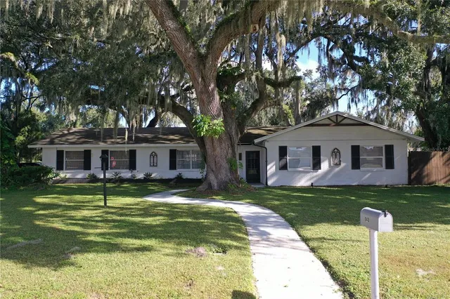 a front view of a house with a garden and trees