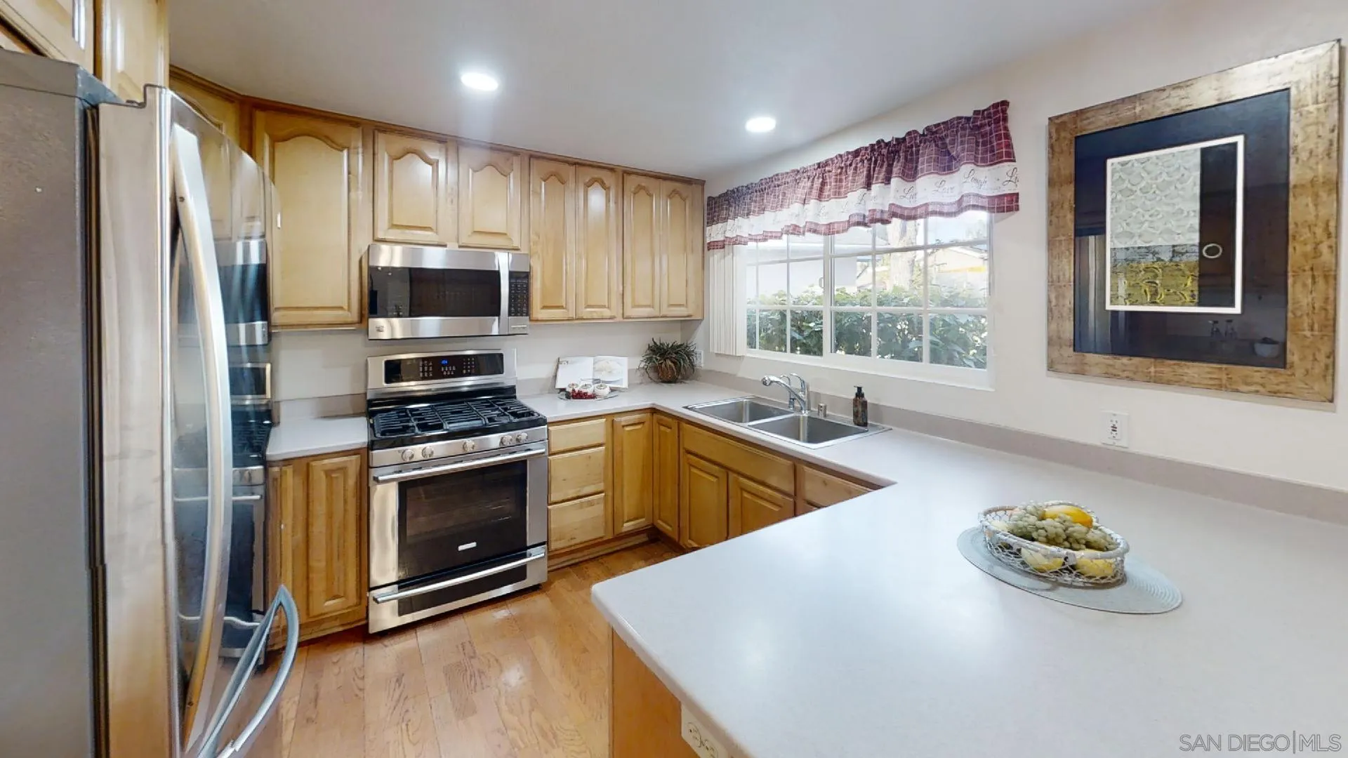 9018 Inverness Road Santee, CA 92071 - Photo 9 of 49 a kitchen with stainless steel appliances a stove a sink a refrigerator white cabinets and wooden floor