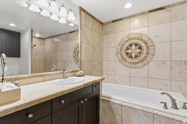 6237 West 4600th Street South Hooper, UT 84315 - Photo 17 of 48 Bathroom with tile walls, a garden tub, vanity, recessed lighting, and tiled shower