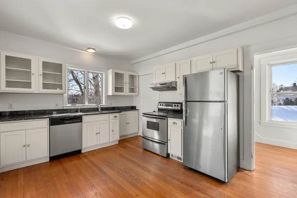 a kitchen with granite countertop stainless steel appliances a refrigerator a sink and cabinets