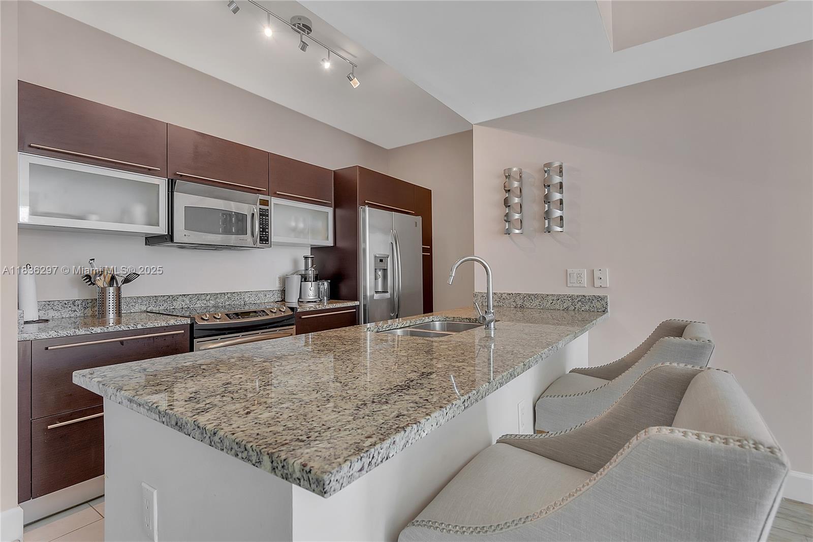 Brickell Miami, FL 33131 - Photo 4 of 17 a kitchen with stainless steel appliances granite countertop a sink stove and cabinets