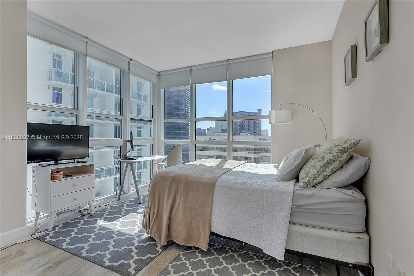 Brickell Miami, FL 33131 - Photo 10 of 17 a living room with furniture a flat screen tv and a refrigerator