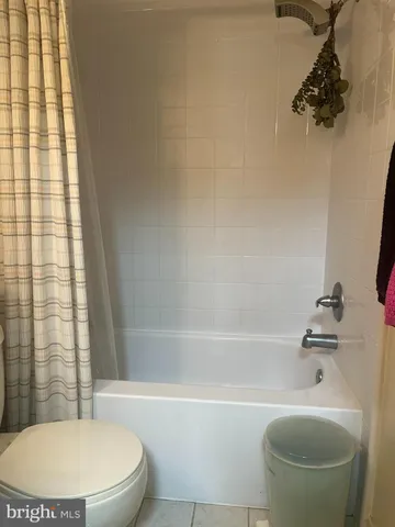 a white toilet and tub sitting next to a bathroom sink