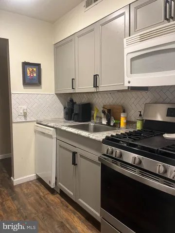 a kitchen with stainless steel appliances granite countertop a sink and a stove