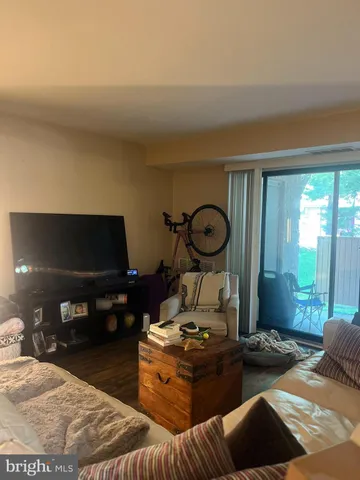 a living room with furniture a flat screen tv and a floor to ceiling window