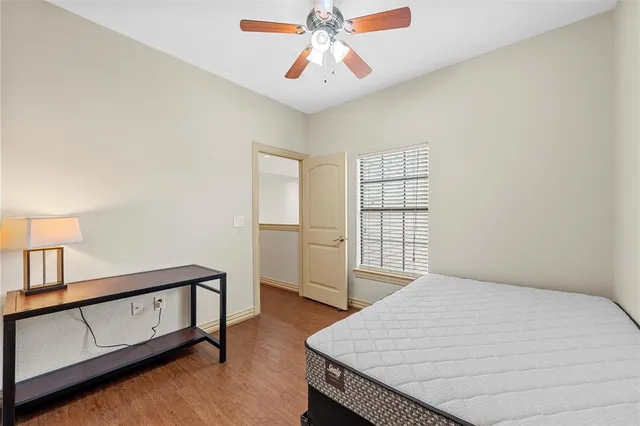 a bedroom with a bed a dresser and the window