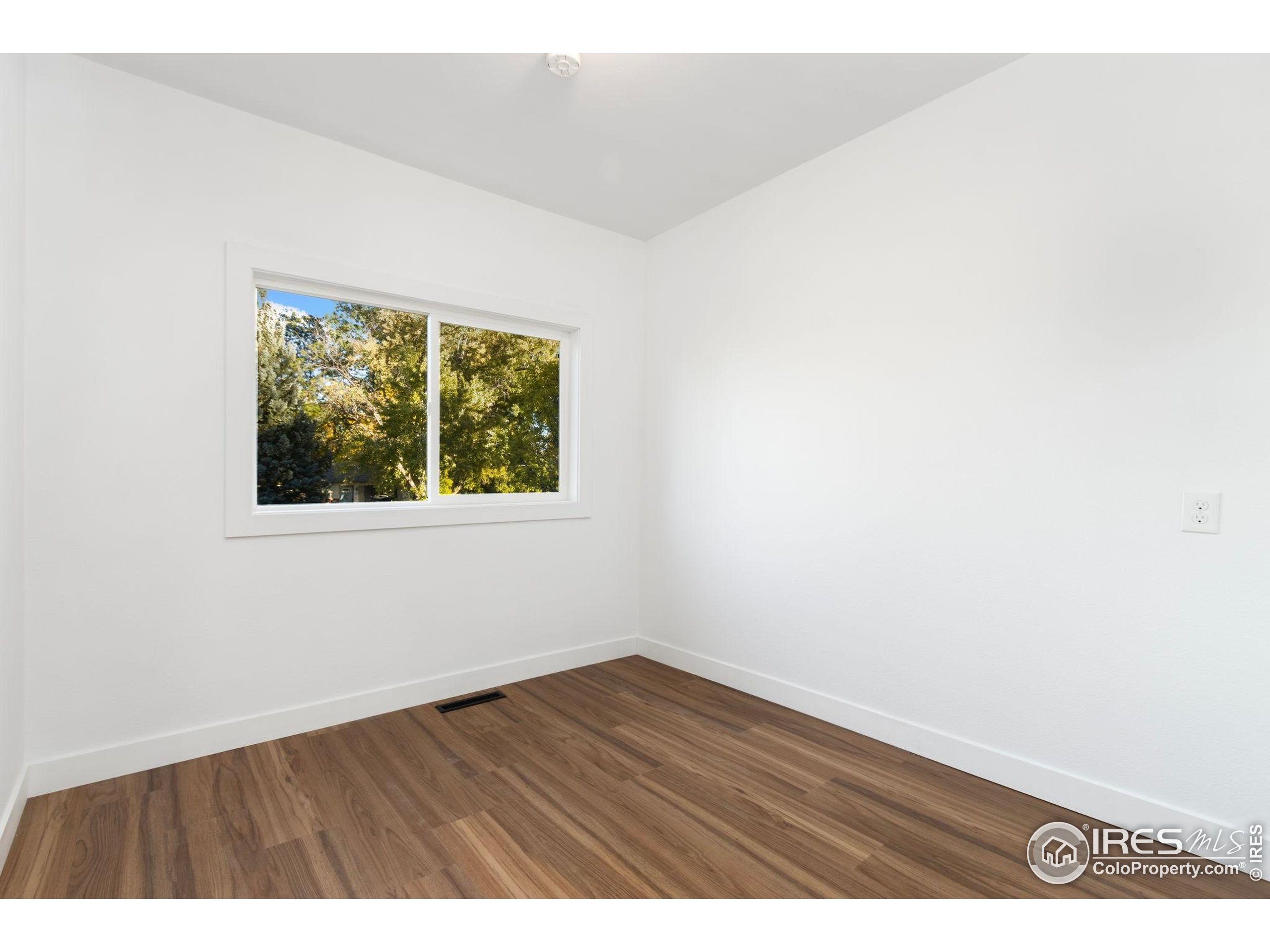 437 Clover Lane Fort Collins, CO 80521 - Photo 7 of 22 a view of an empty room with wooden floor and a window