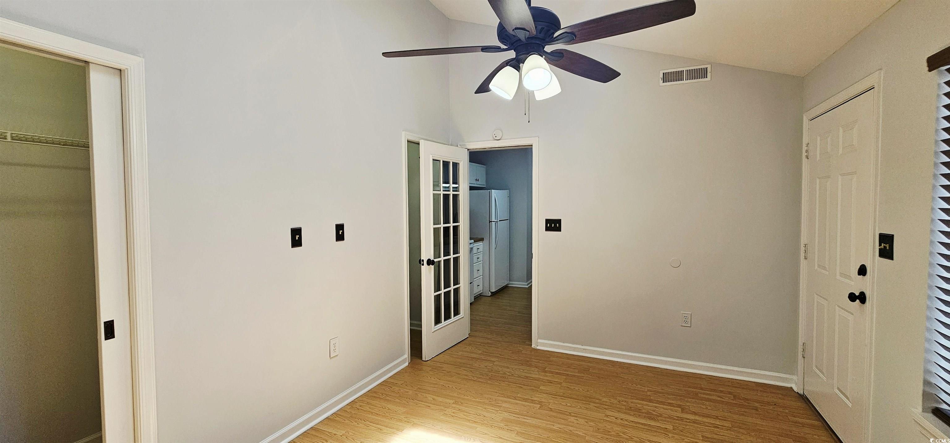 615 13th Avenue South, Unit 137 Surfside Beach, SC 29575 - Photo 18 of 40 Unfurnished bedroom featuring a closet, light wood-type flooring, freestanding refrigerator, ceiling fan, and high vaulted ceiling