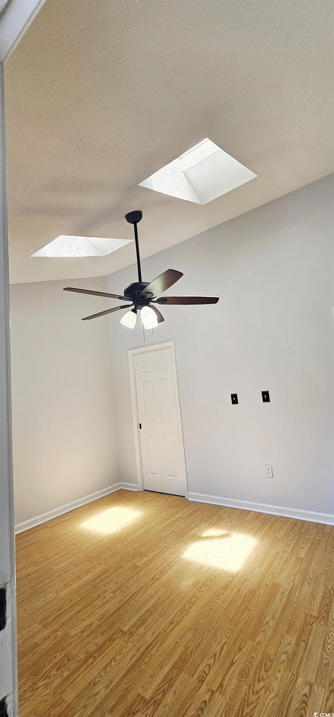 615 13th Avenue South, Unit 137 Surfside Beach, SC 29575 - Photo 22 of 40 Unfurnished room featuring light wood-type flooring, a skylight, lofted ceiling, ceiling fan, and a textured ceiling