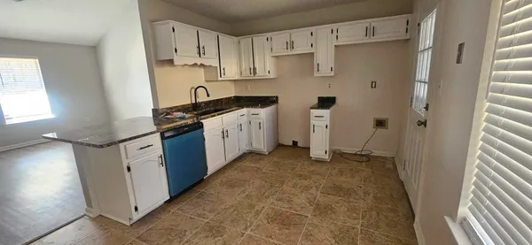a kitchen with stainless steel appliances a refrigerator sink and white cabinets