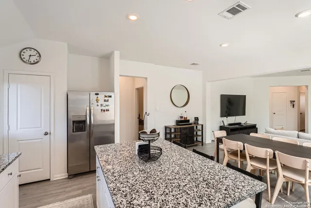 a kitchen with stainless steel appliances granite countertop a refrigerator and stove top oven