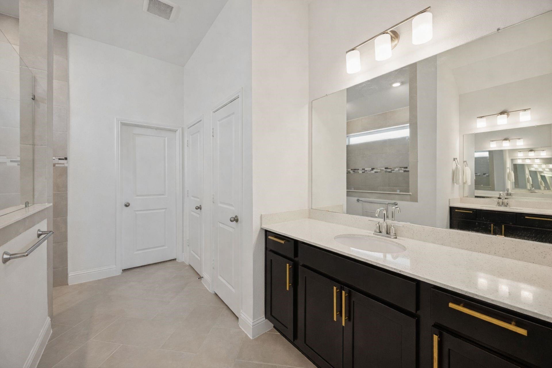 16022 Tangled Vine Lane Conroe, TX 77302 - Photo 18 of 30 a bathroom with a double vanity sink a mirror and shower