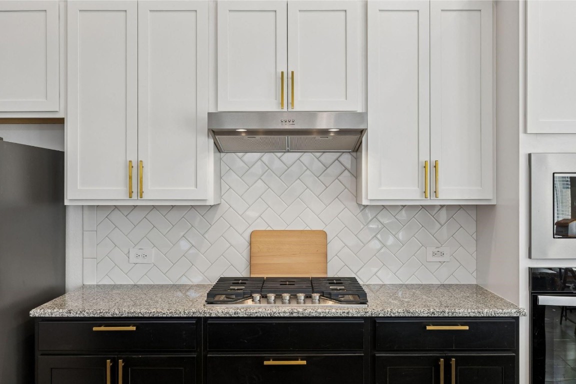 16022 Tangled Vine Lane Conroe, TX 77302 - Photo 8 of 30 a kitchen with granite countertop a stove and a white cabinets