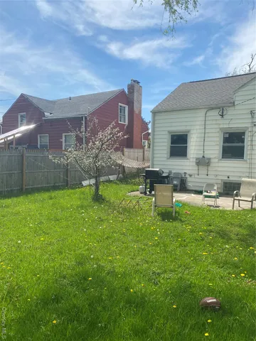 a backyard of a house with table and chairs