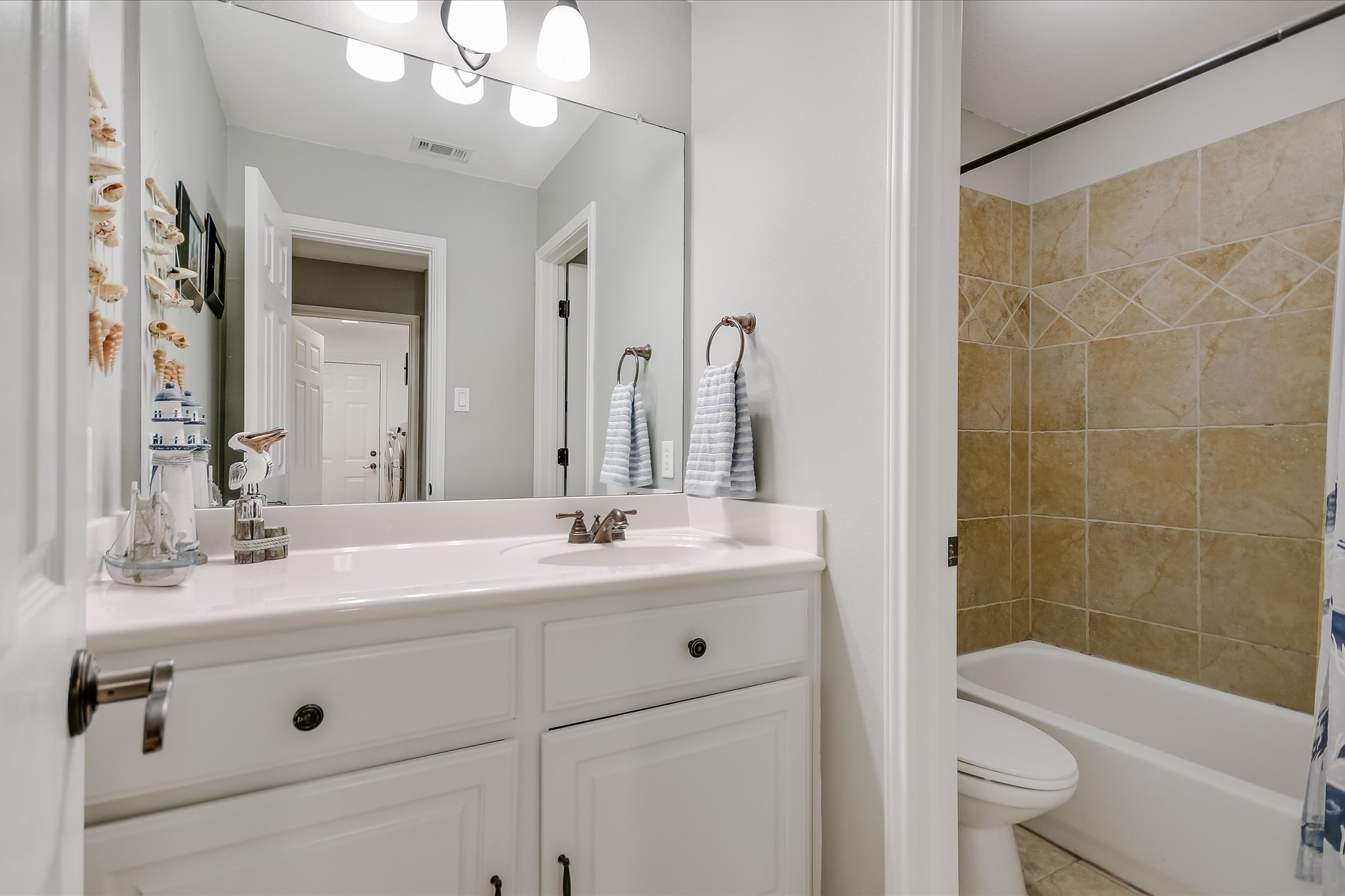 300 Wesley Ridge Drive Spicewood, TX 78669 - Photo 22 of 40 The secondary bath on the main floor features a practical design with a tiled tub-shower combination and spacious vanity.