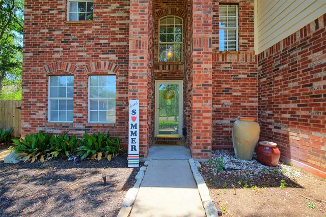 a view of a brick house with potted plants