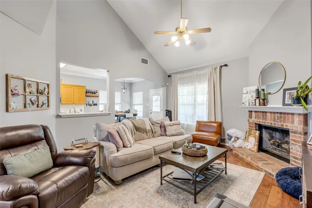 a living room with furniture a fireplace and a chandelier