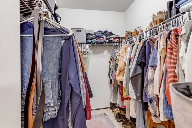 a view of walk in closet with clothes