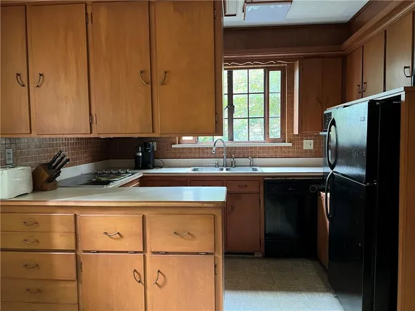 a kitchen with a sink a refrigerator and cabinets