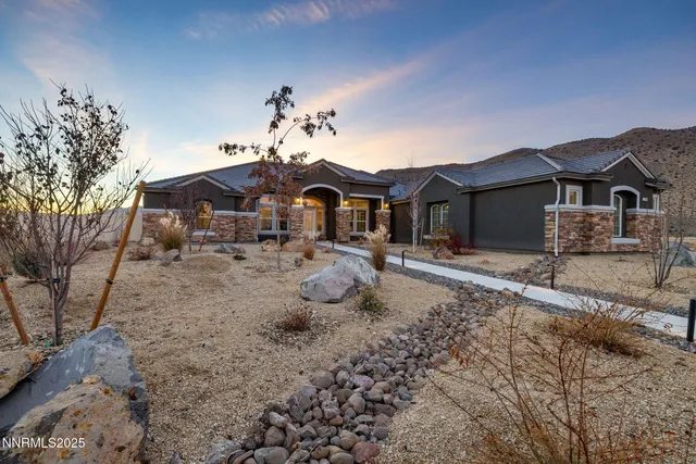 a front view of a house with a yard and potted plants