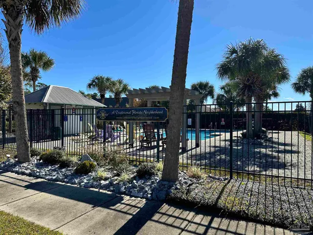 an aerial view of a house with swimming pool and large trees