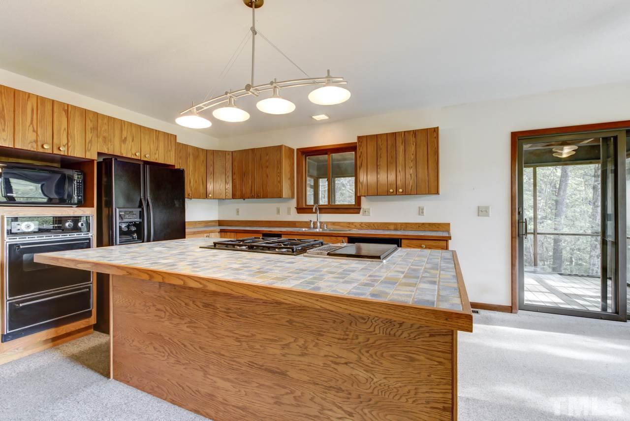 1600 Center Grove Church Road Moncure, NC 27559 - Photo 12 of 25 Extra special touches! Large center island w/gas range, grill, Dacor dishwasher, 2 ovens (1 wall oven), microwave, refrigerator, plus a walk in pantry. Tons of cabinets and tile counters.