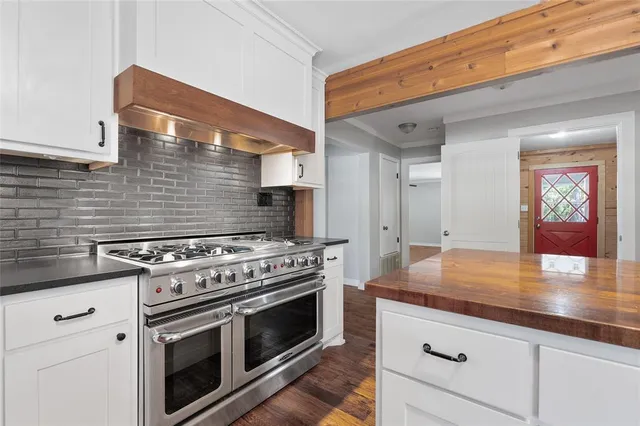 a kitchen with granite countertop a stove and a wooden floor