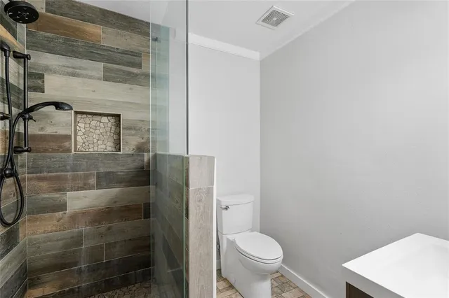 a bathroom with a toilet and a shower