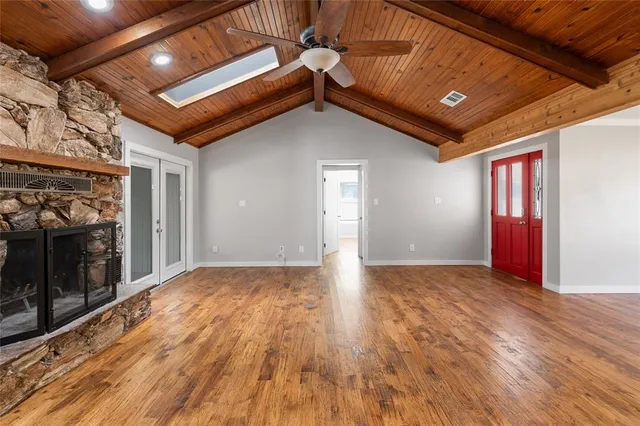 a view of an empty room with wooden floor