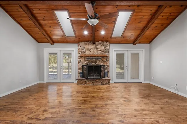 a view of an empty room with a fireplace and a window