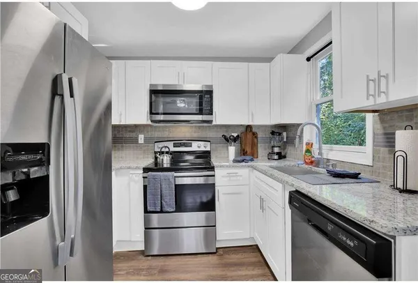 a kitchen with white cabinets and stainless steel appliances