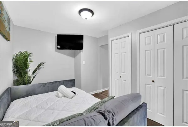 a bedroom with a bed and a flat screen tv