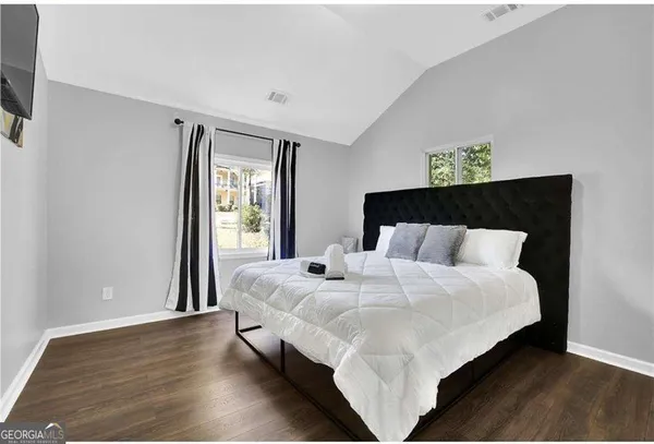 a large bed sitting in a bedroom next to a window