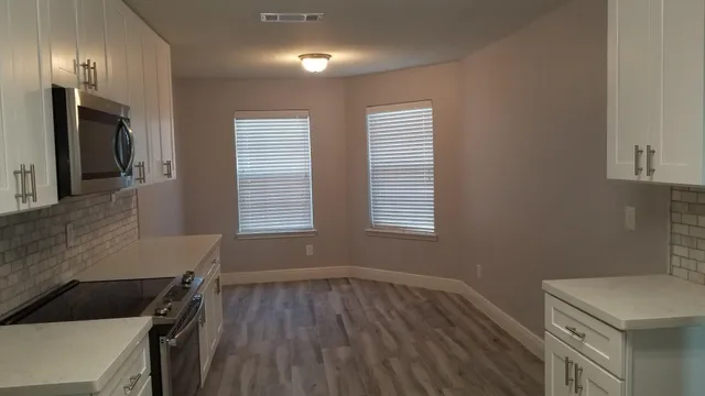 a kitchen with a wooden floor and a window