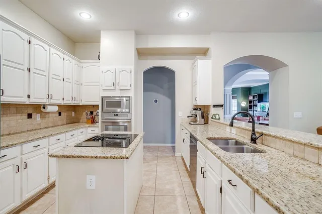 a kitchen with stainless steel appliances granite countertop a sink stove and cabinets
