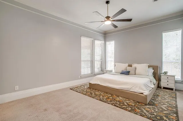 a bedroom with a large bed window and a ceiling fan