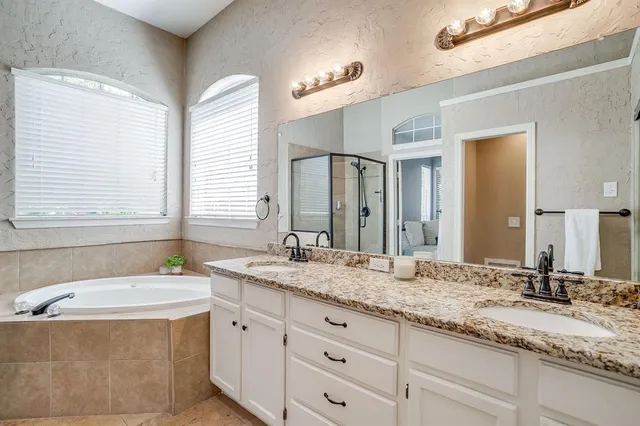 a bathroom with a granite countertop sink and a bathtub