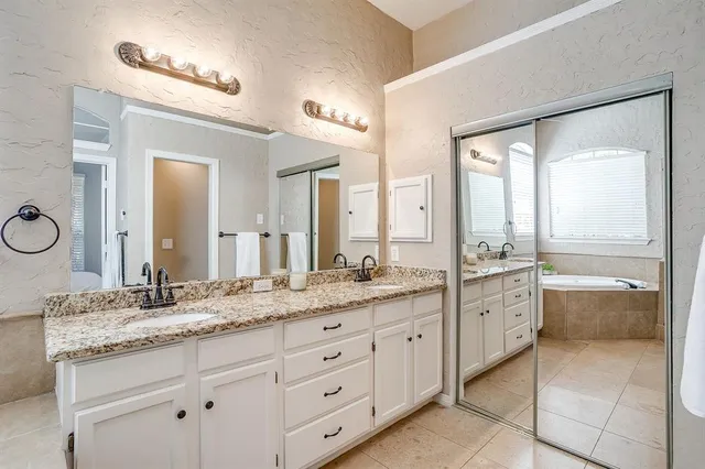a bathroom with a granite countertop sink mirror and bathtub