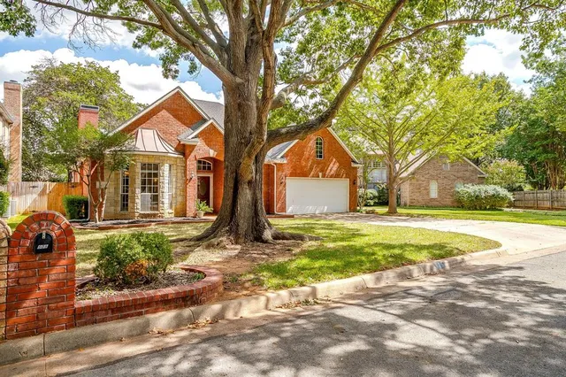 a view of a house with backyard and tree
